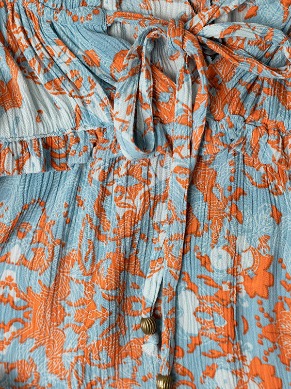 Blå klänning i crepeviskos med orange mönster fra Adia